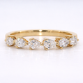 Gold ring with pear-shaped diamonds on a white background
