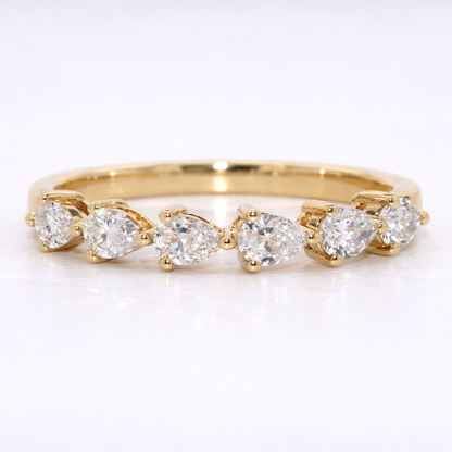 Gold ring with pear-shaped diamonds on a white background