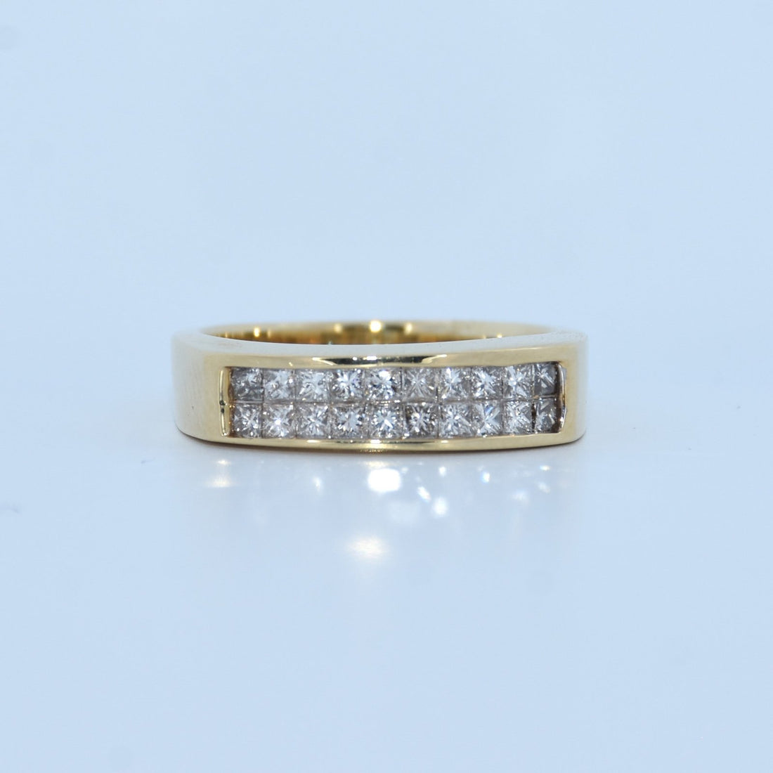 Gold ring with embedded diamonds on a light blue background