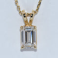 Gold pendant with a rectangular gemstone on a white background