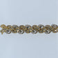 Gold and silver bracelet with rhinestones on a light gray background