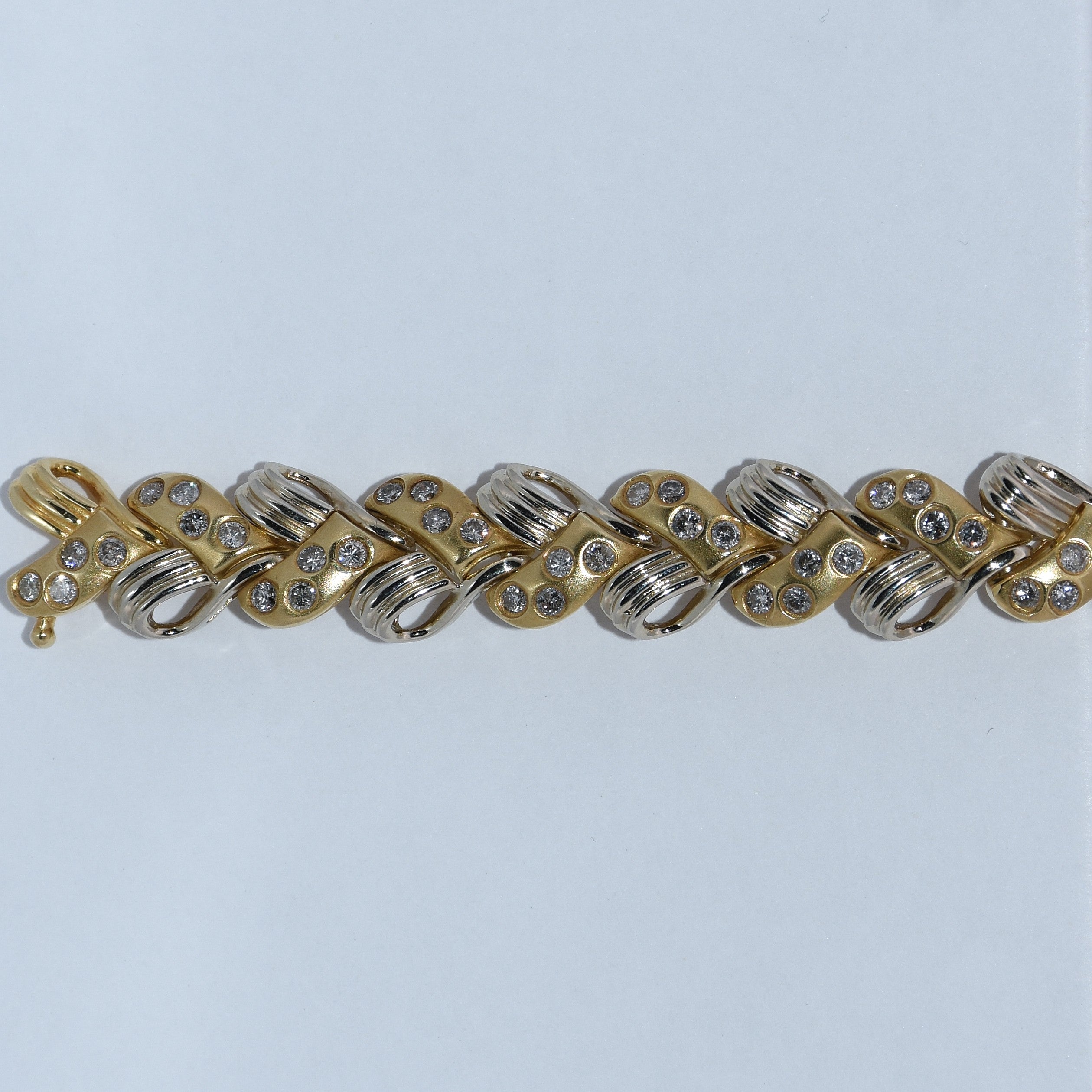 Gold and silver bracelet with rhinestones on a light gray background