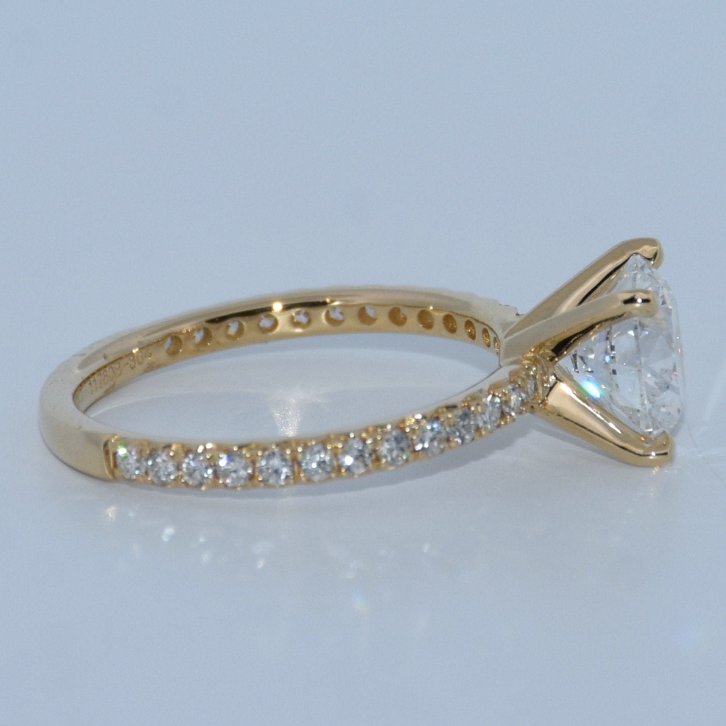Gold ring with a pear-shaped diamond on a light gray background