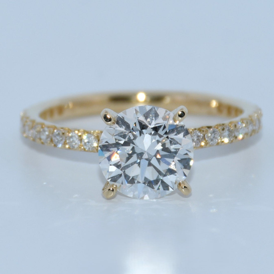 Gold ring with a diamond on a light gray background