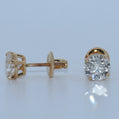 Pair of rose gold diamond earrings on a light gray background