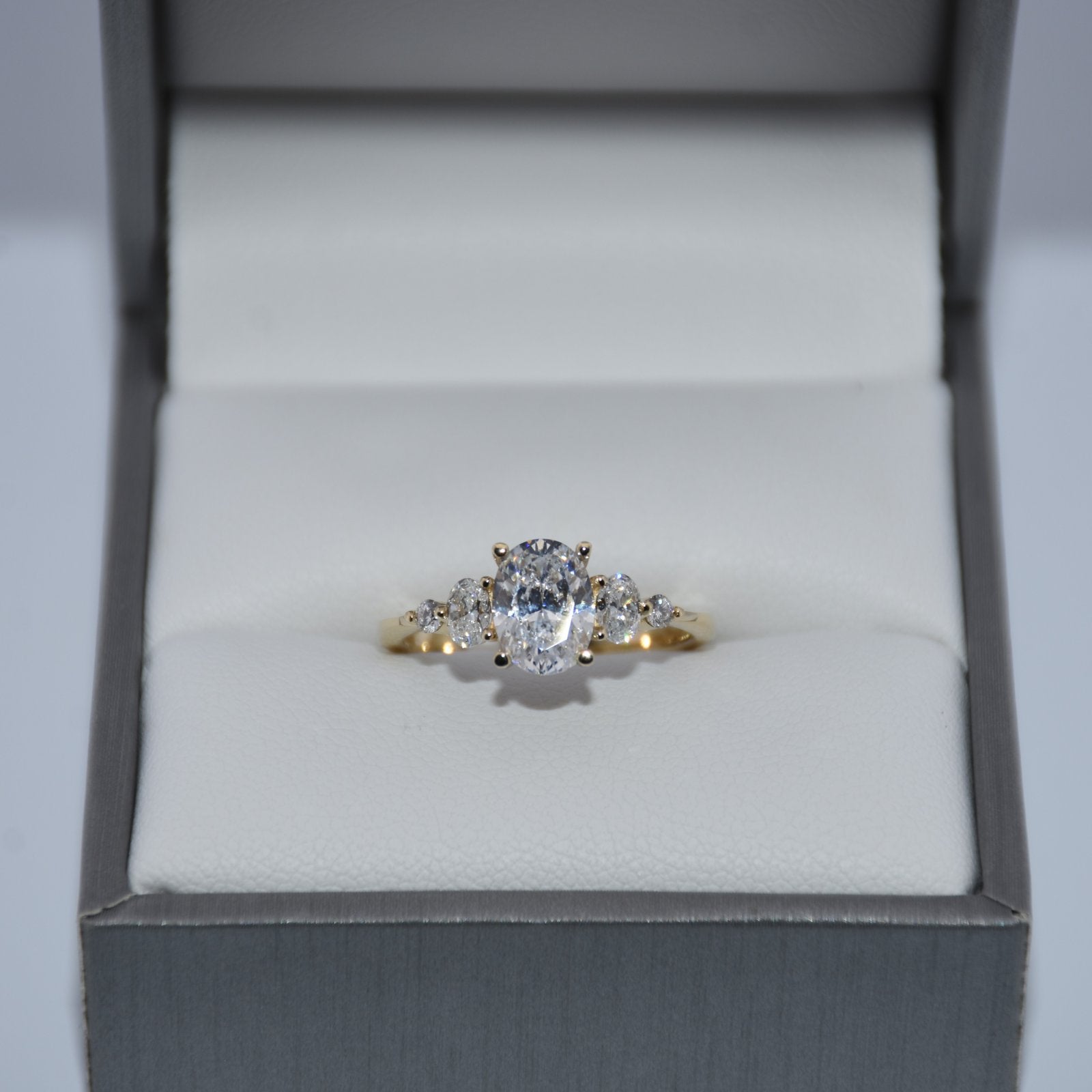 Diamond ring in a gray jewelry box on a light gray background