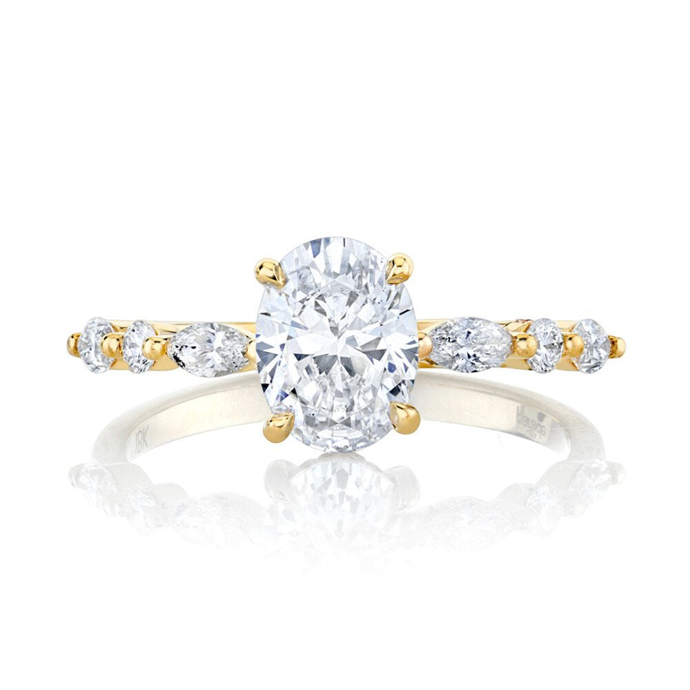 Gold and silver ring with a large central diamond and smaller diamonds on the sides on a white background