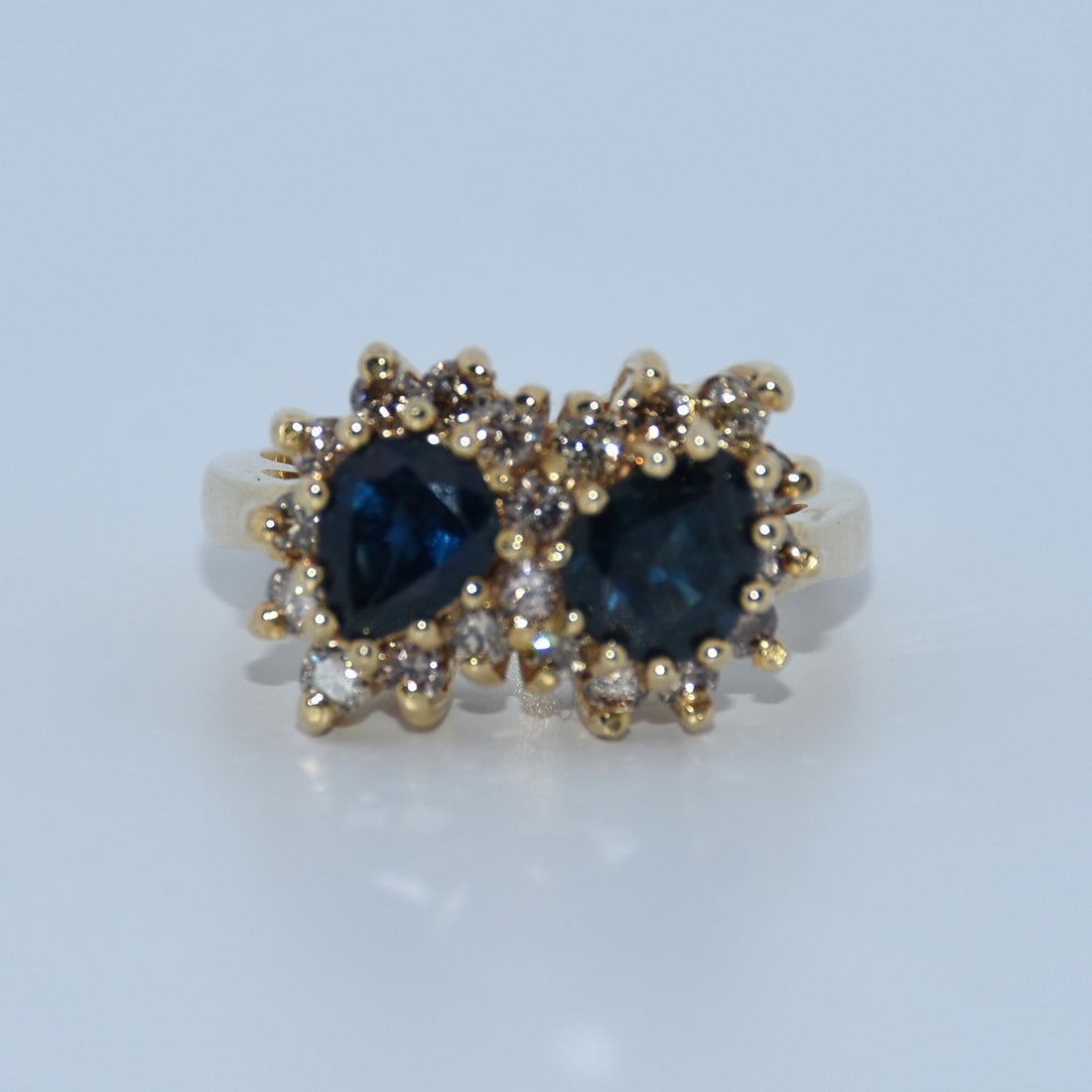 Gold earrings with blue gemstones on a light gray background