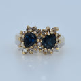 Gold earrings with blue gemstones on a light gray background