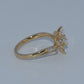 Gold ring with a diamond on a light gray background