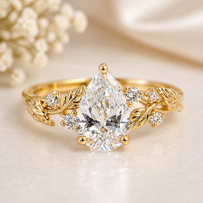 Gold ring with a large pear-shaped diamond and smaller diamonds on a soft background