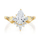 Gold ring with a pear-shaped diamond on a white background