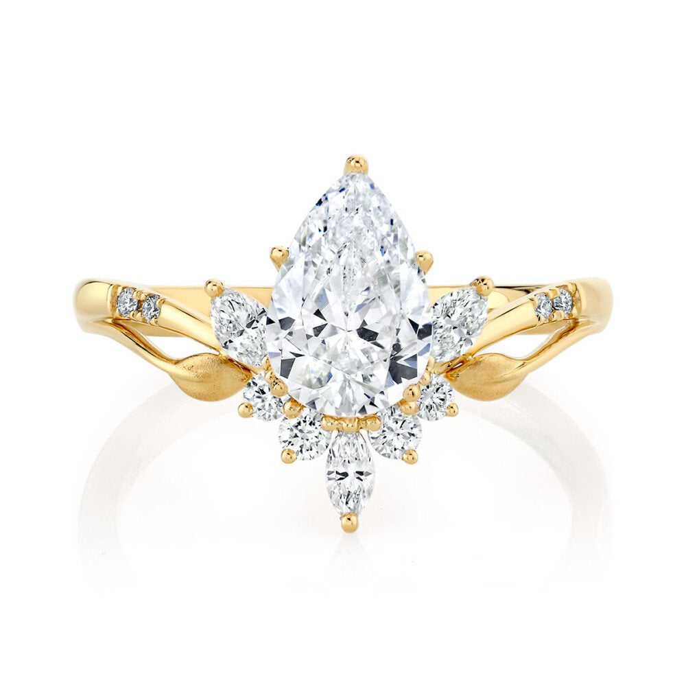 Gold ring with a pear-shaped diamond on a white background