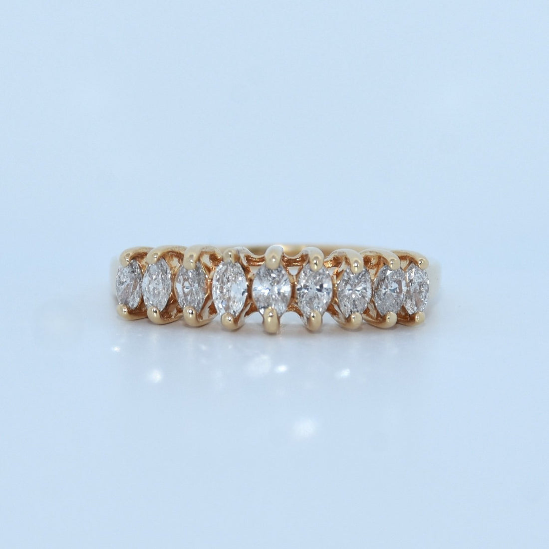 Gold ring with diamonds on a light blue background