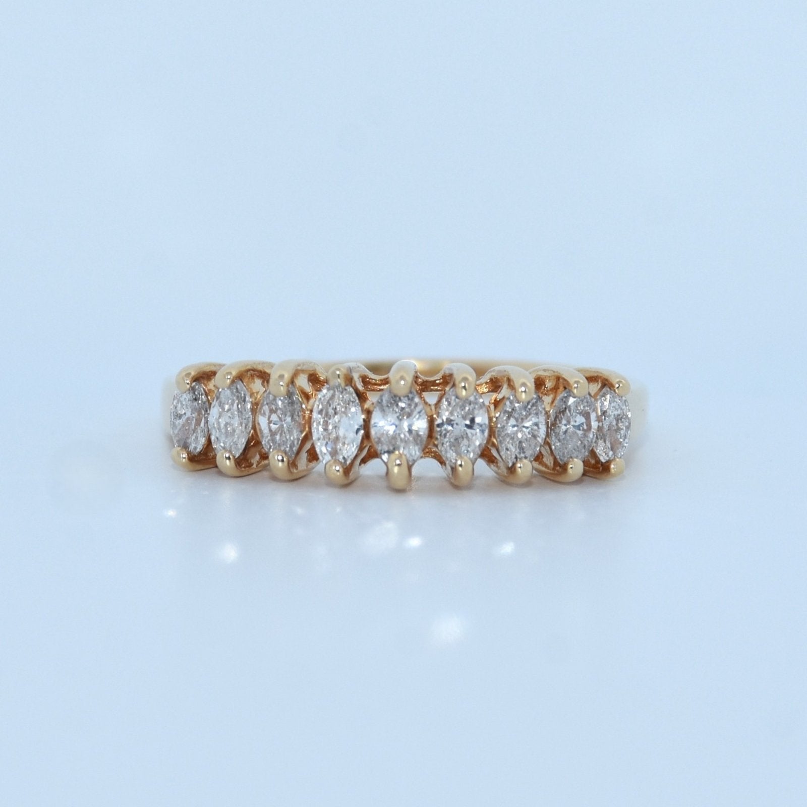 Gold ring with diamonds on a light blue background