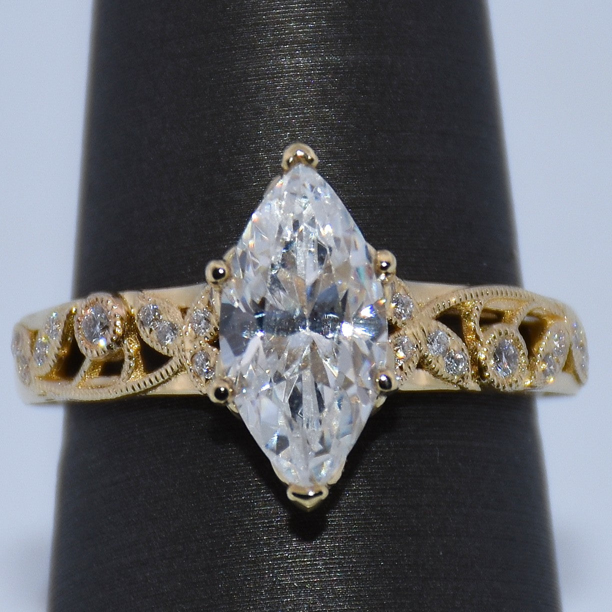 Gold ring with a large diamond on a black stand