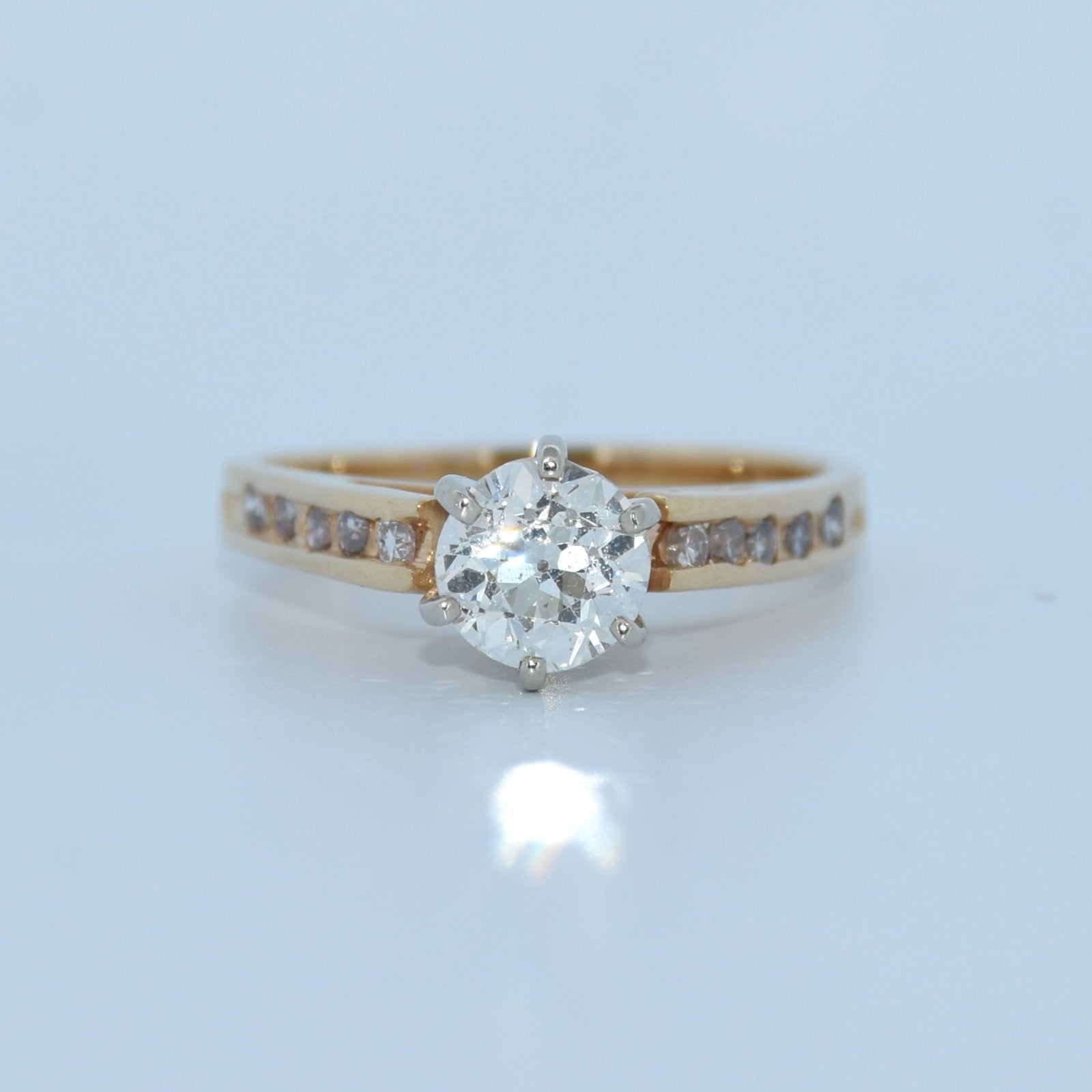 Gold ring with a diamond on a light blue background