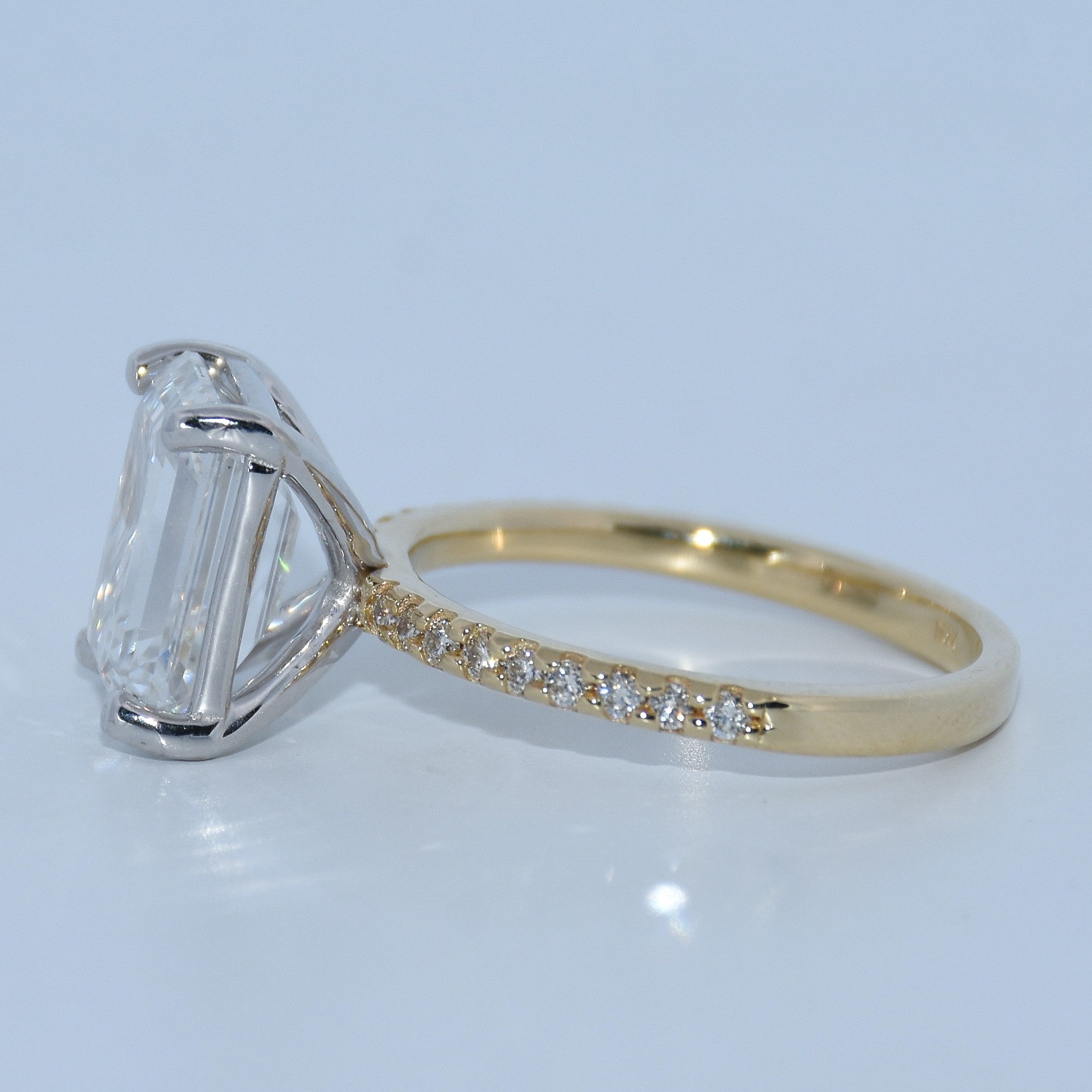 Gold ring with a diamond and another ring with a large diamond on a light gray background