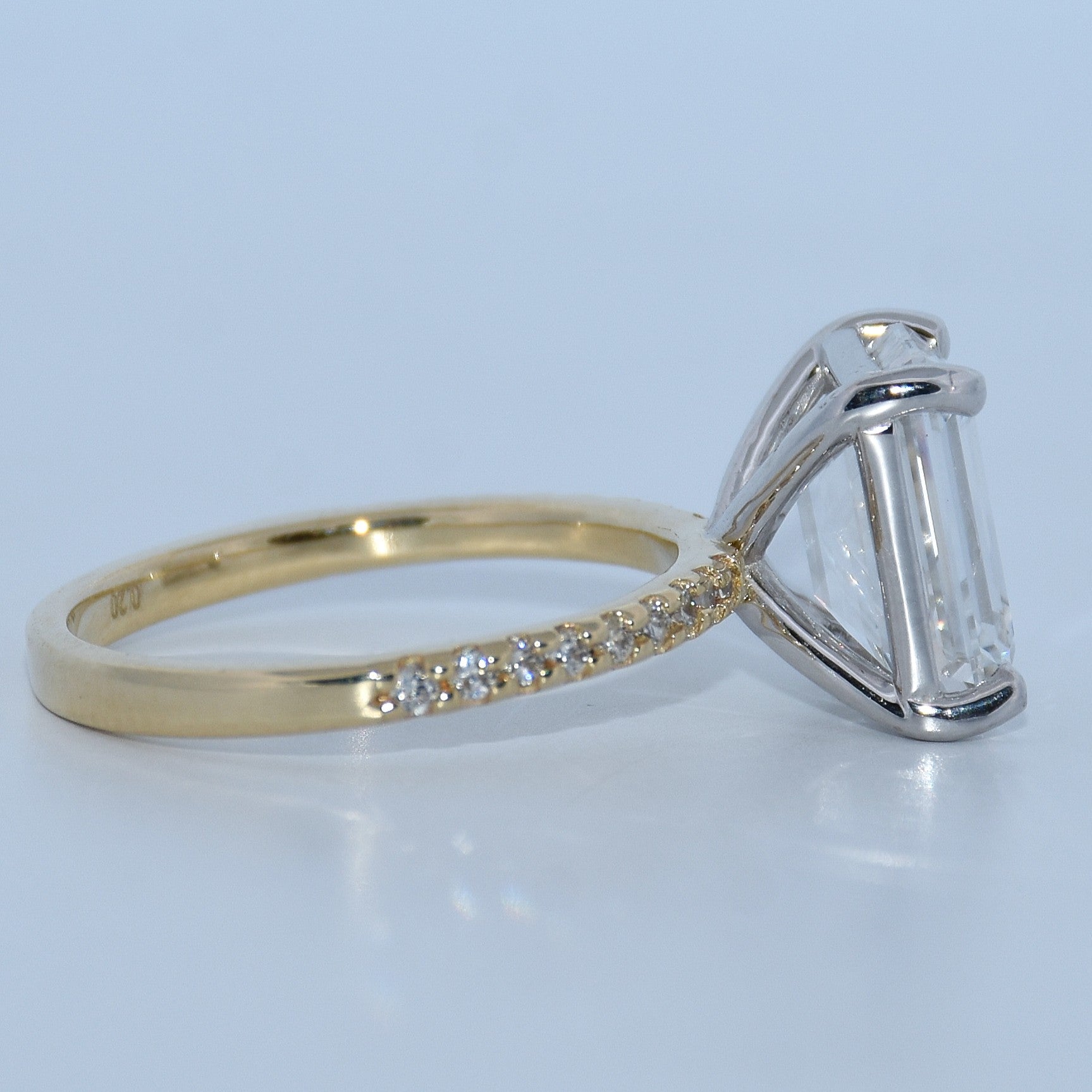 Gold and silver ring with diamond accents on a light gray background
