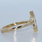 Gold ring with a clear gemstone on a light gray background