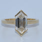 Gold ring with a large rectangular diamond on a light blue background