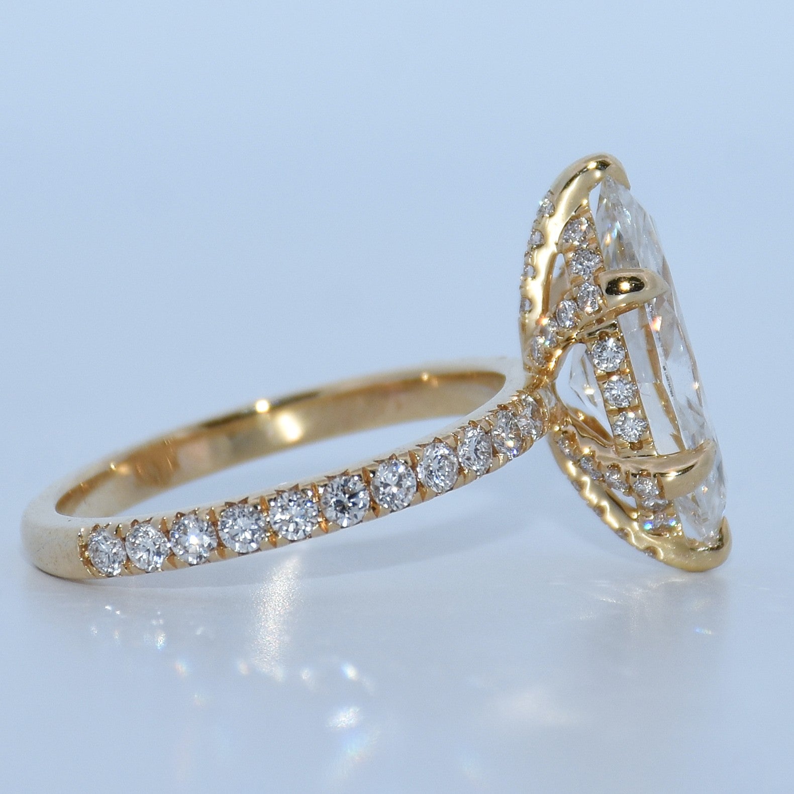 Gold ring with diamond accents on a light blue background