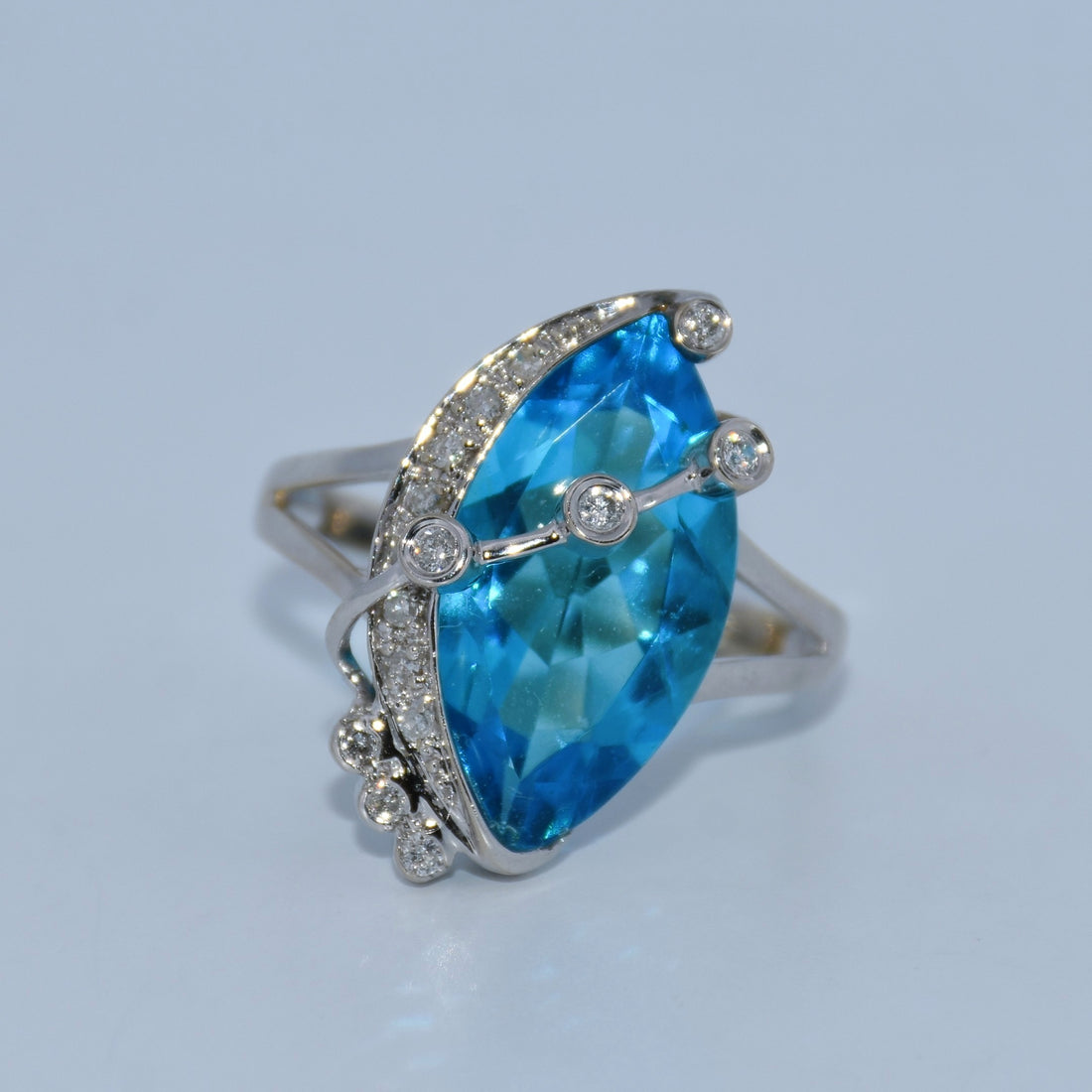 Ring with a blue gemstone and silver accents on a light gray background