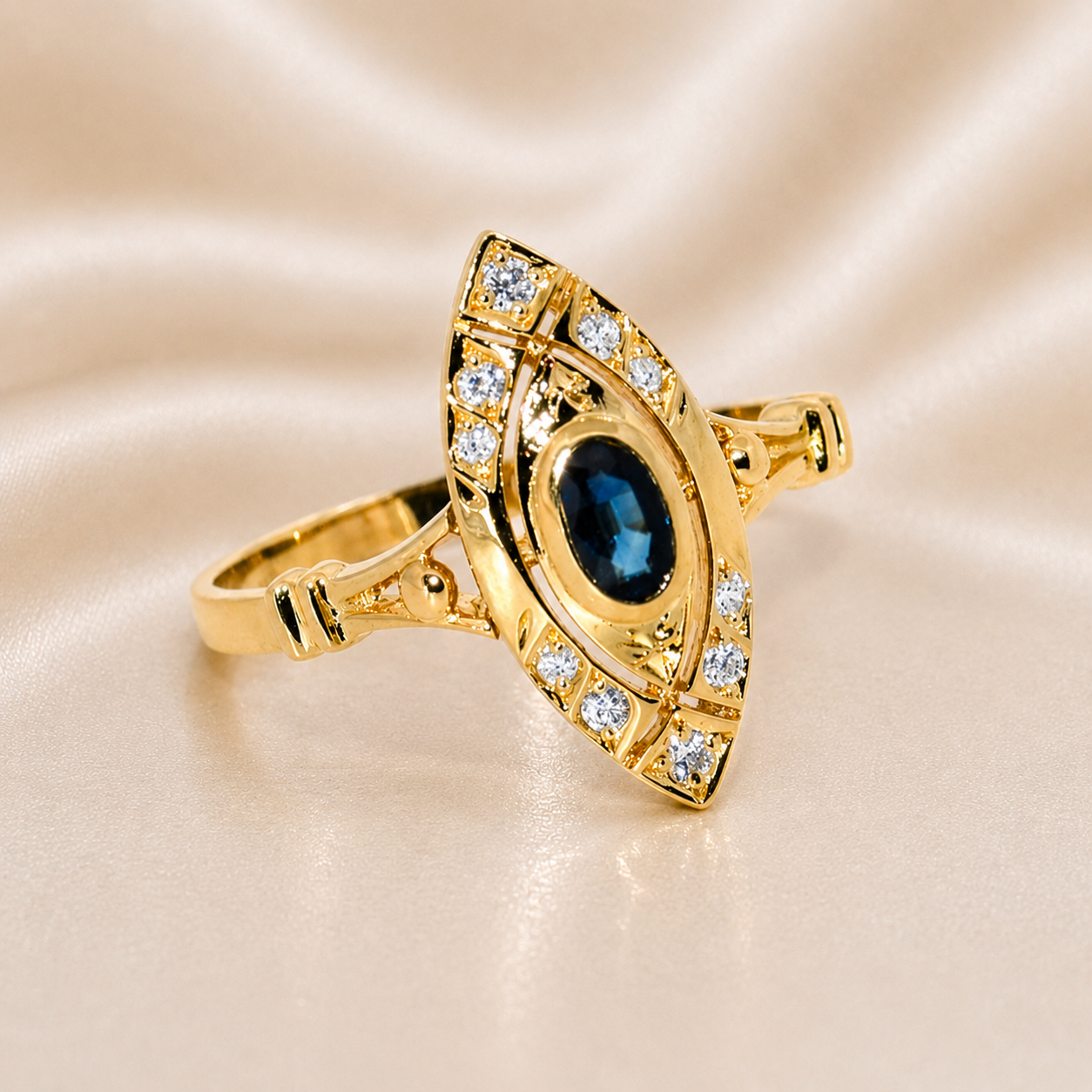 Gold ring with blue gemstone and diamond accents on a beige fabric background 19.2K Portuguese Gold | .35ct Natural Oval Blue Sapphire .15ct Natural Diamond Ring