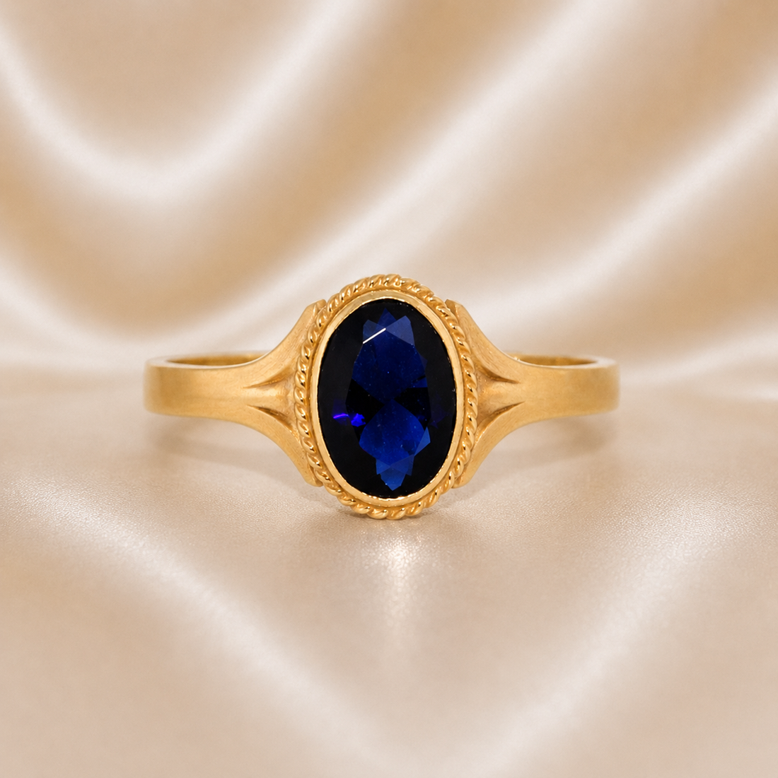 Gold ring with a blue gemstone on a beige fabric background 19.2K Portuguese Gold | Baby Oval Sapphire Ring 