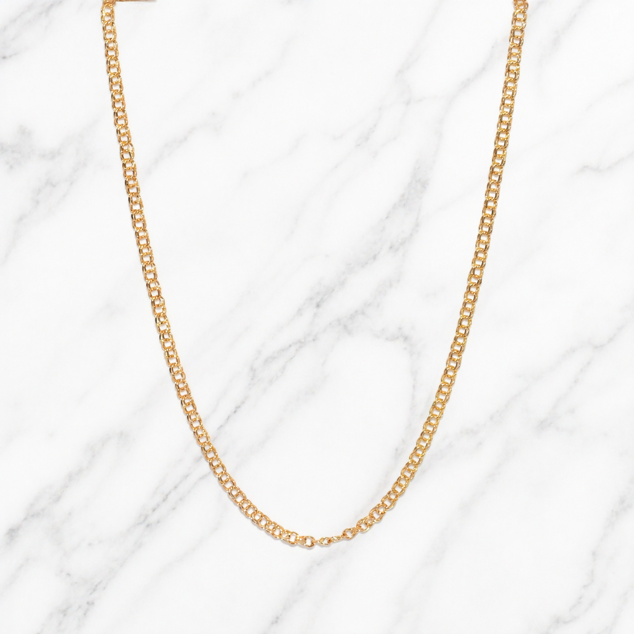 19.2k Portuguese Gold freeze chain 2mm 20" necklace on a marble background