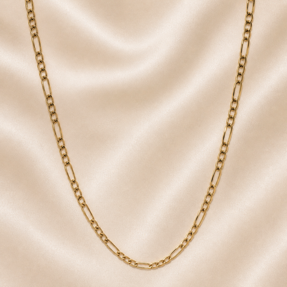 Gold chain necklace on a beige fabric background 19.2K Portuguese Gold | 20" Solid Figaro Chains
