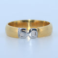 Gold ring with a silver '50' design on a light blue background