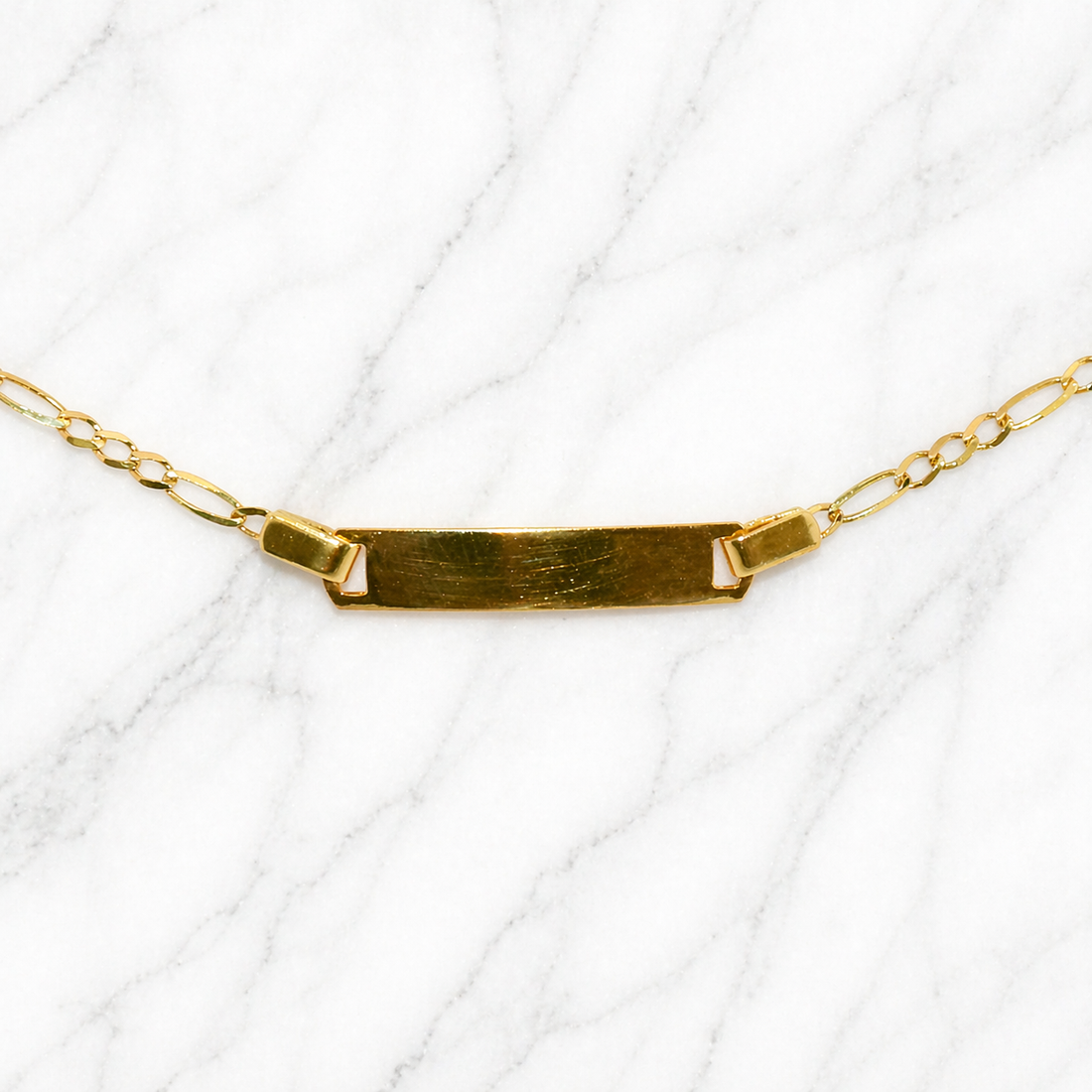 19.2K Portuguese Gold | 6" Kids Figaro ID Bracelet with Adjustable Links Gold necklace with a bar pendant on a white background