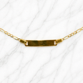 19.2K Portuguese Gold | 6" Kids Figaro ID Bracelet with Adjustable Links Gold necklace with a bar pendant on a white background