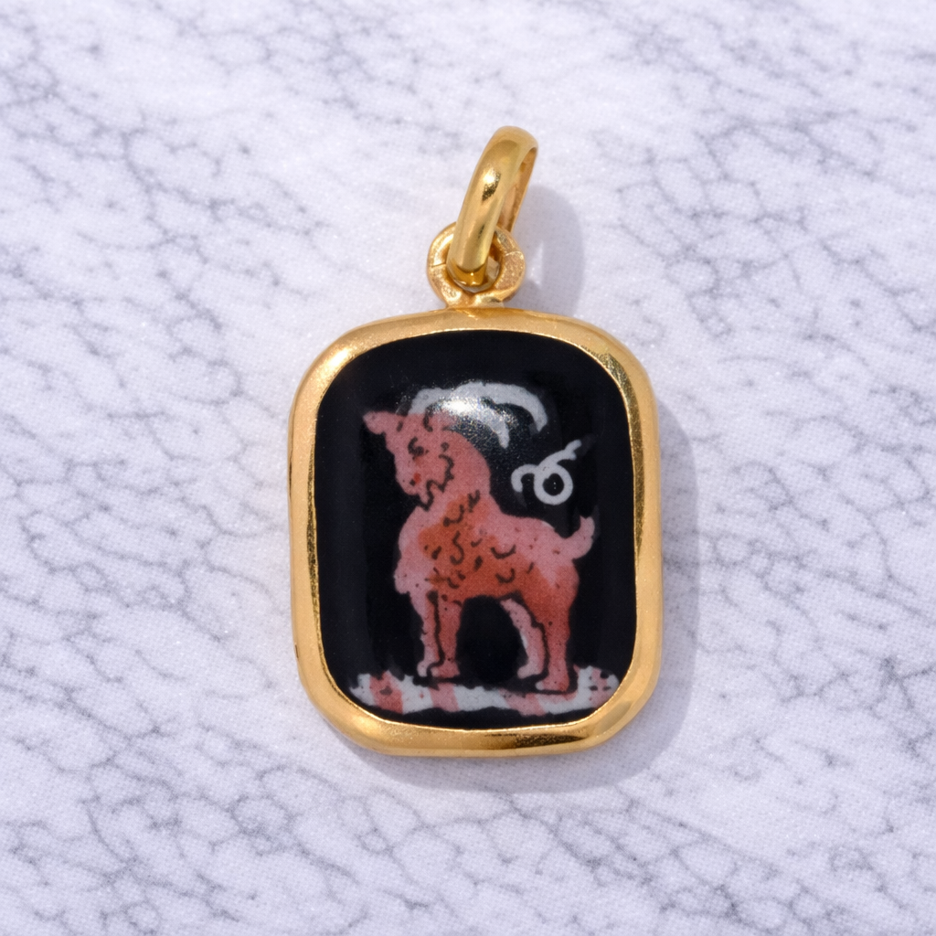 19.2K Portuguese Gold pendant with a pink/red Capricorn goat design on a textured white background