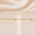 Gold bracelet with infinity symbols on a beige satin background 19.2K Portuguese Gold | Dainty Infinity & Ball Bracelet