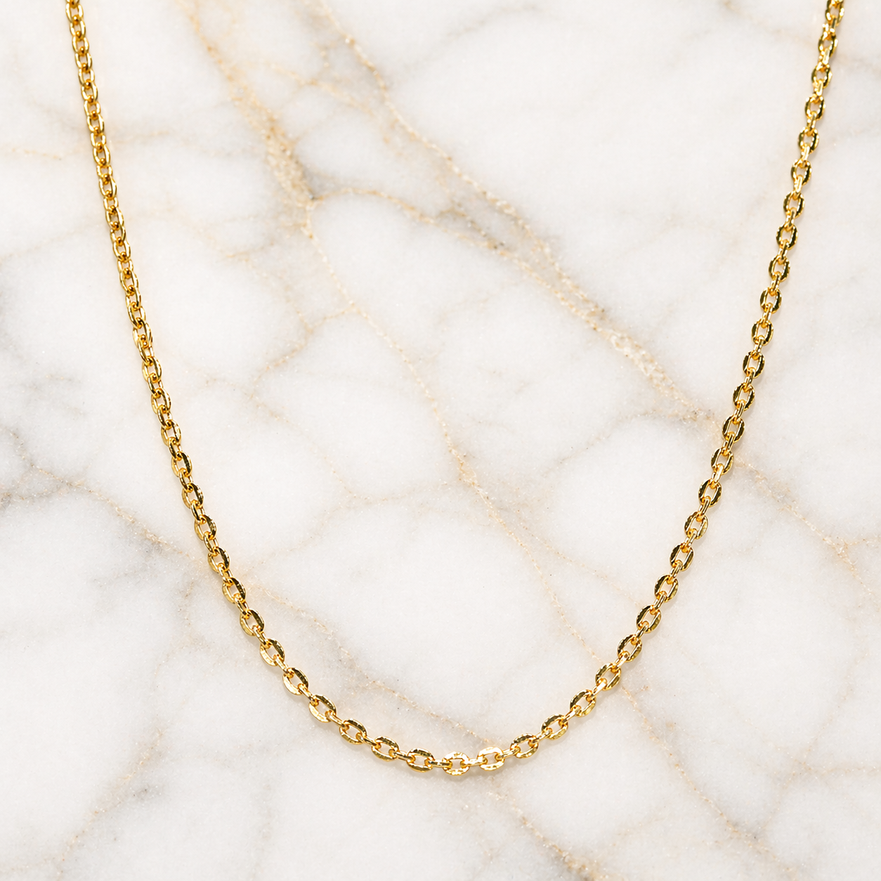 Gold chain necklace on a marble surface 19.2K Portuguese Gold | Fancy Box Chains