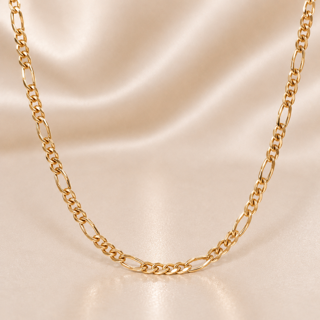 Gold chain necklace on a beige satin background 19.2K Portuguese Gold | Figaro Chain 18"