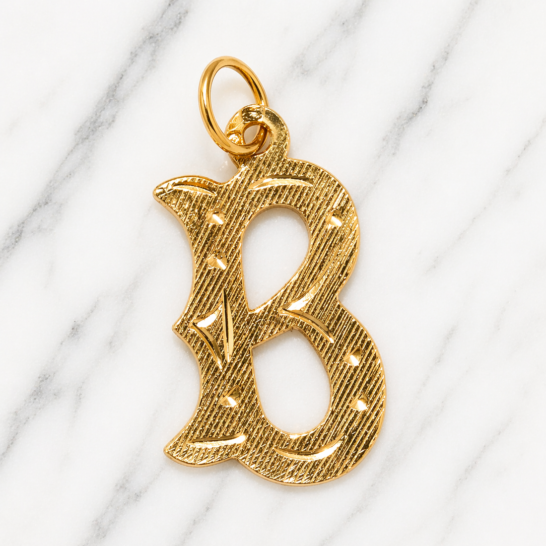 Gold letter 'B' pendant on a marble surface19.2K Portuguese Gold | Large Initial Charm Letter Pendants Large Letter B initial