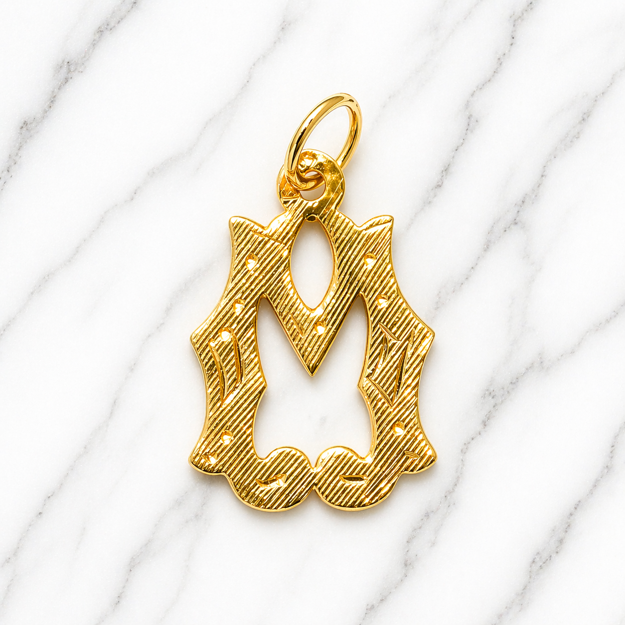 Gold pendant with a decorative design on a marble surface 19.2K Portuguese Gold | Large Initial Charm Letter Pendants Leter M 