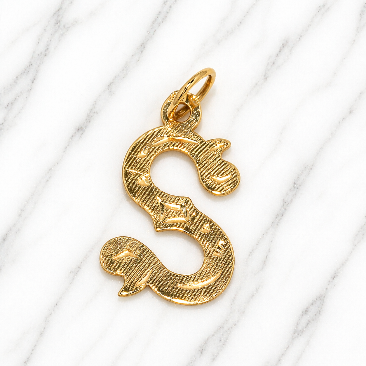 Gold 'S' shaped pendant on a marble background 19.2K Portuguese Gold | Large Initial Charm Letter Pendants