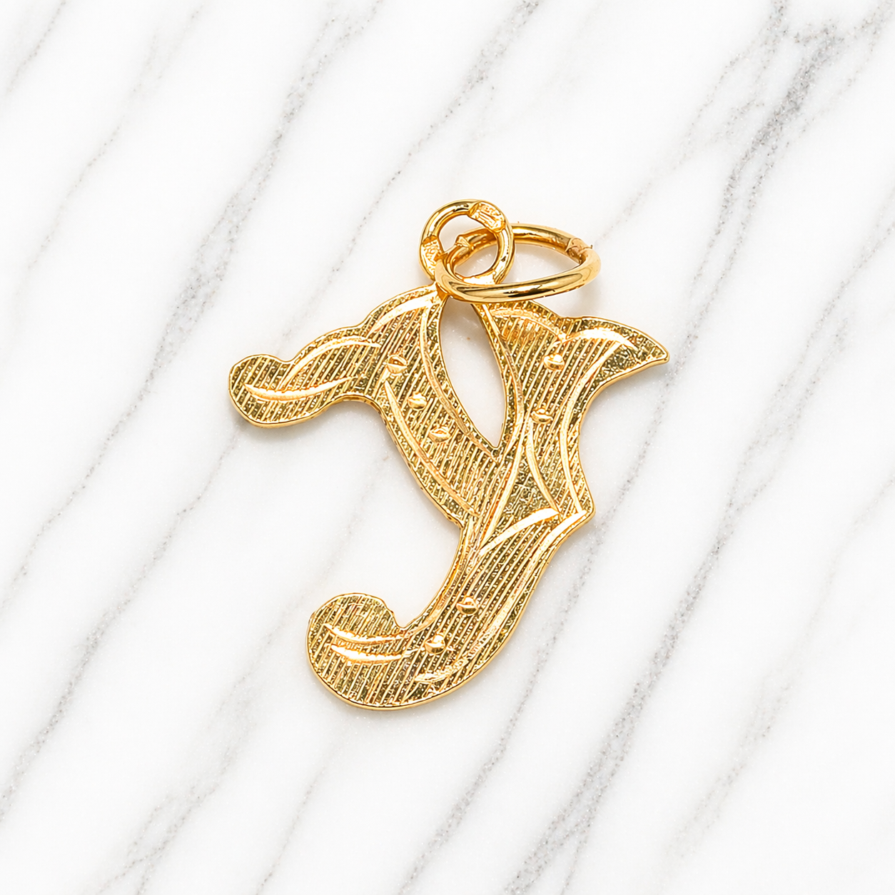 Gold letter 'Y' pendant on a white marble background 19.2K Portuguese Gold | Large Initial Charm Letter Pendants