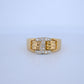 Gold ring with diamond accents on a light blue background