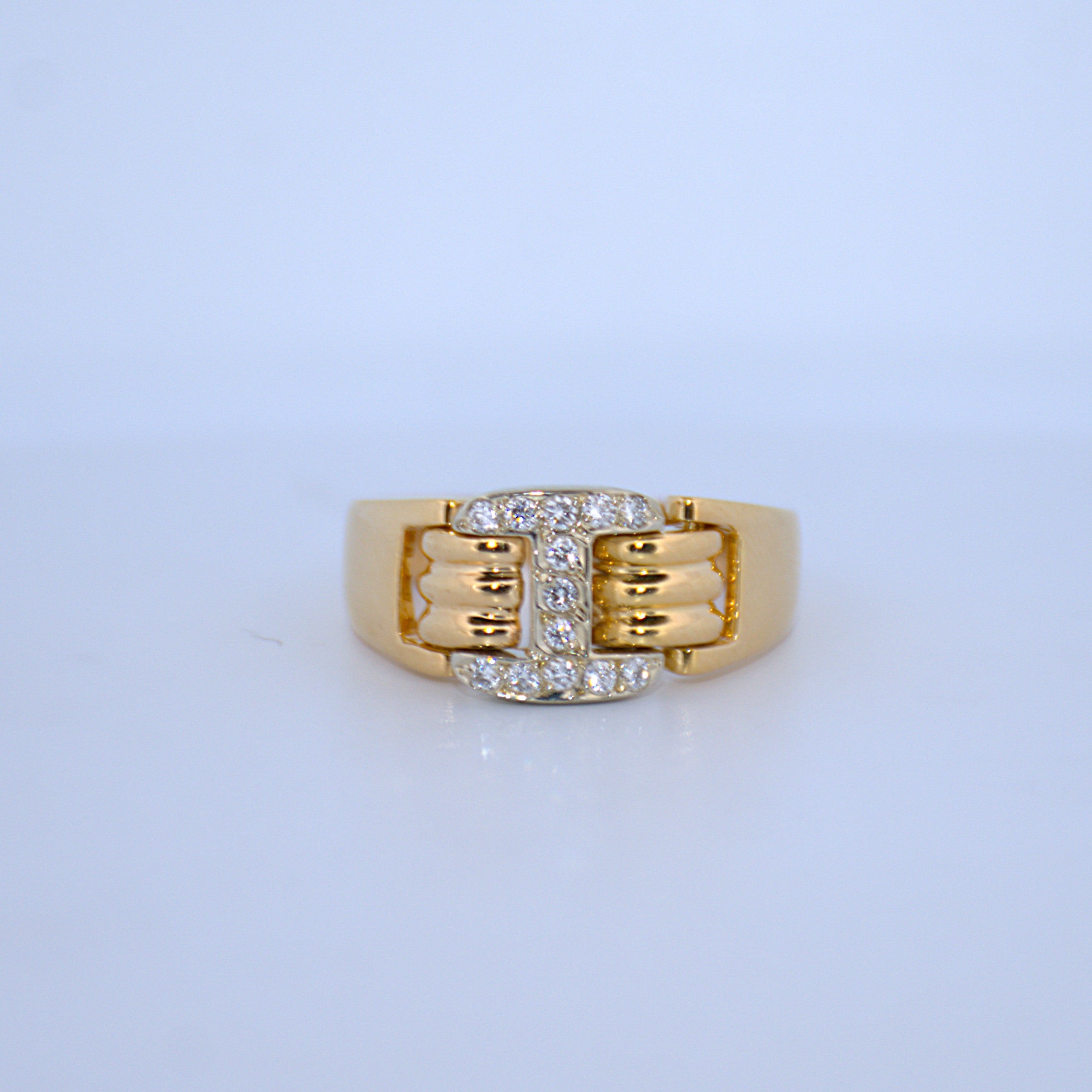 Gold ring with diamond accents on a light blue background