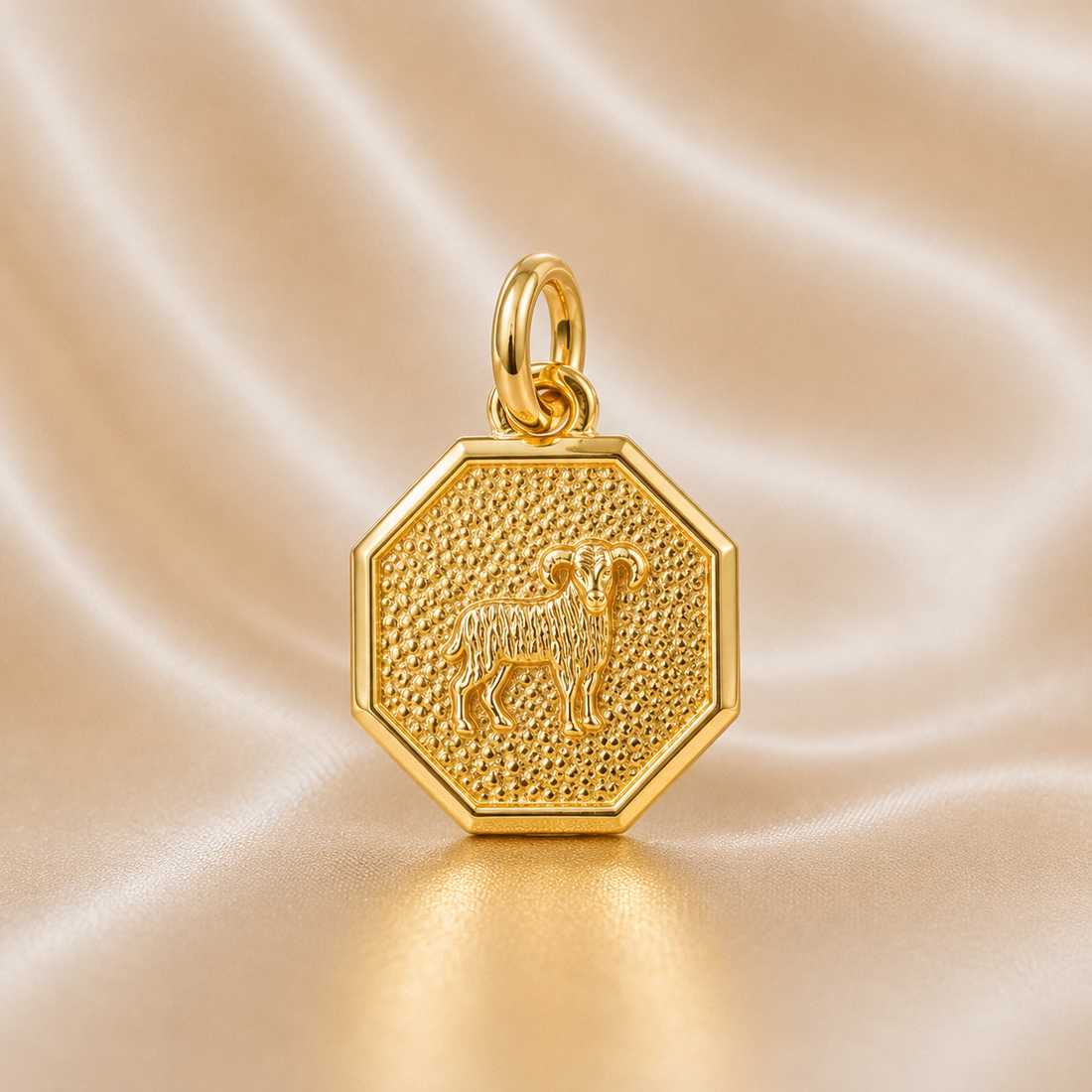 Gold hexagonal pendant with a engraved design on a beige sa tin background 19.2K Portuguese Gold | Octagon Zodiac Charms Aries 