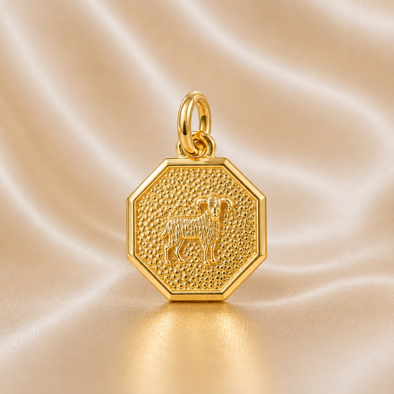 Gold hexagonal pendant with a engraved design on a beige sa tin background 19.2K Portuguese Gold | Octagon Zodiac Charms Aries 