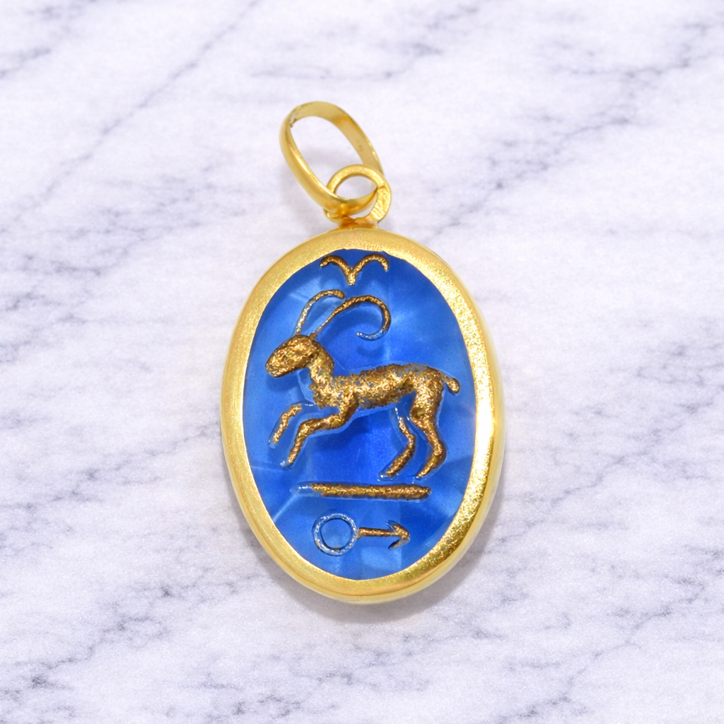 19.2K Portuguese Gold Aries Zodiac Sign pendant with blue stone and goat design on a marble background