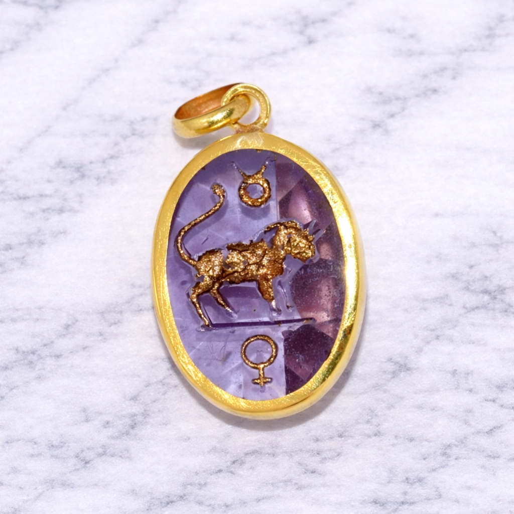 19.2K Portuguese Gold Taurus Zodiac Sign pendant with a purple stone featuring a lion design on a marble background