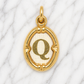 Gold pendant with letter 'Q' on a marble background 19.2K Portuguese Gold | Oval Initial Charms