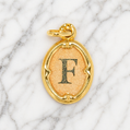 Gold pendant with letter 'F' on a marble background 19.2K Portuguese Gold | Oval Initial Charms
